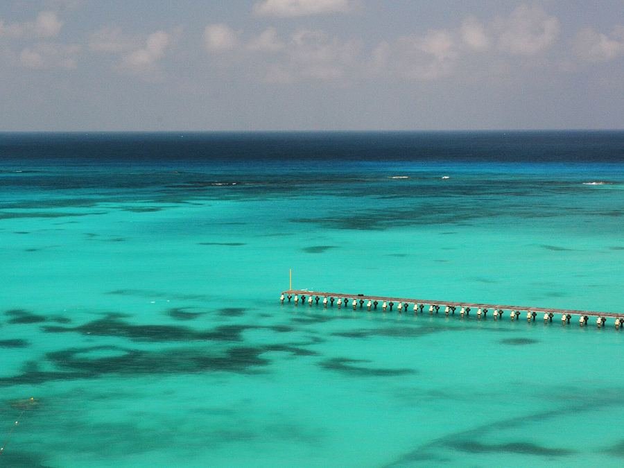 Aguas turquesa del Caribe frente a Cancún con un muelle al fondo