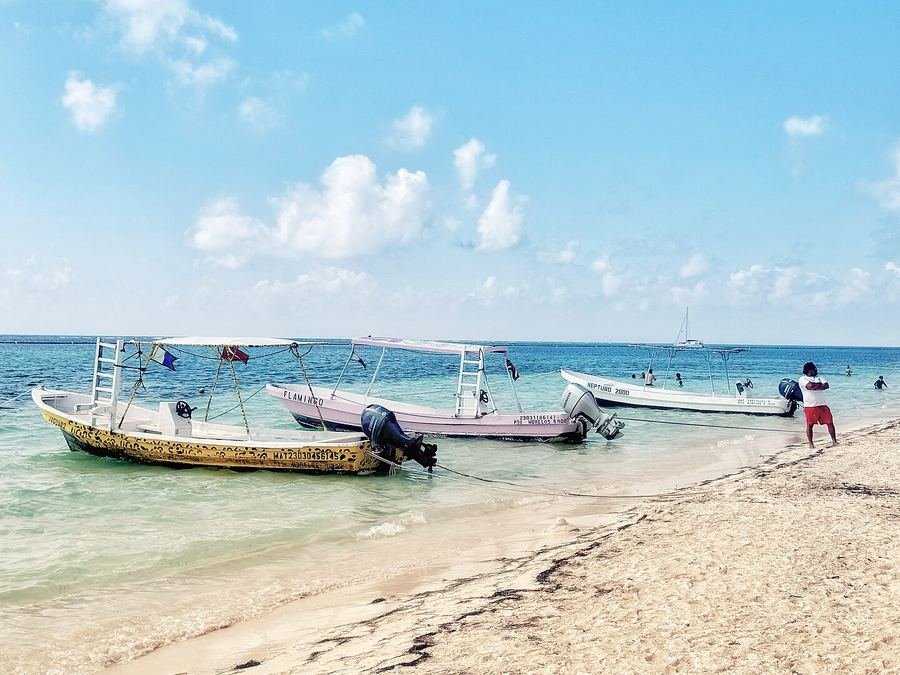 Lanchas en la playa de Puerto Morelos, en la Riviera Maya, con aguas turquesa