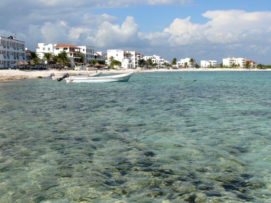 Aguas cristalinas y lanchas frente a la costa de Akumal, Riviera Maya